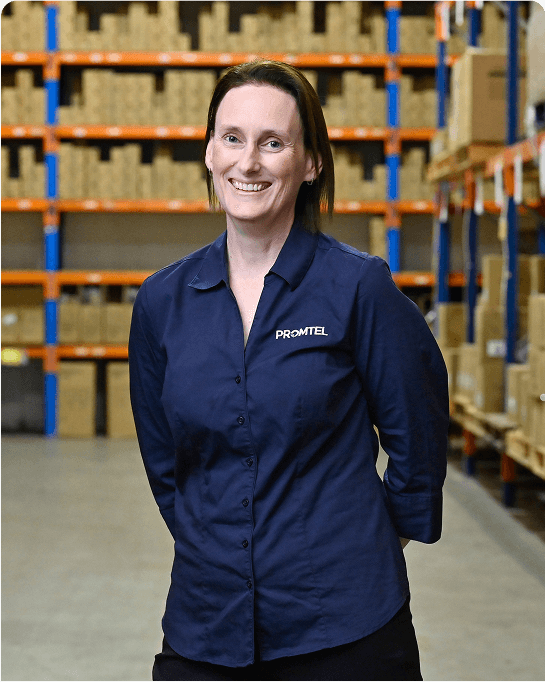 A Promtel staff standing in front of the stocks shelf smiling brightly