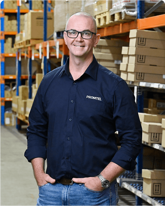 Michael a Promtel team meber standing and smiling in navy shirt